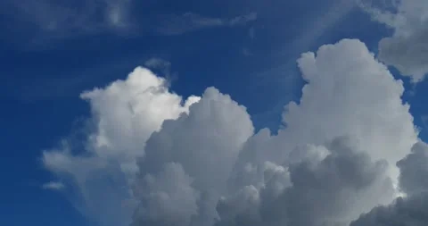 Pan left past 3 thunder heads to deep blue sky, hold Stock Footage 137542926