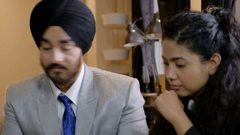 Pan left to right and back as a livid and angry turbaned Sikh boss is seeking an Stock Footage 102082354