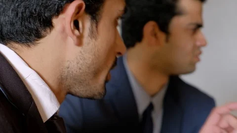 Pan left to right as a bunch of colleagues sitting in a meeting table and discus Stock Footage 104538477