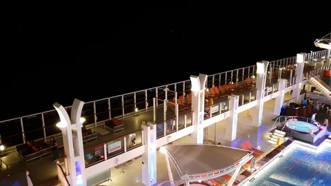 Pan from left to right on cruise swimming pool - night Stock Footage