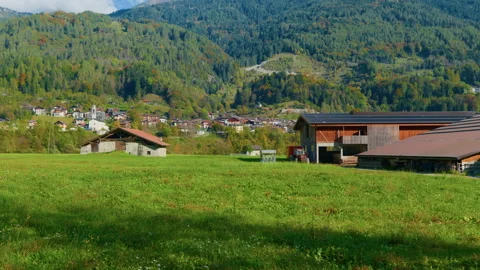 Pan from Left to Right of Mountain Farm with Barn and Alpine Valley Stock Footage 320205845