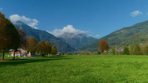 Pan from Left to Right of Mountain Valley with Farms, Barns, and Tractor Stock Footage 320236514
