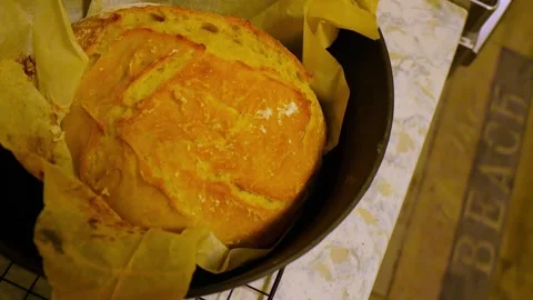 Pan left to right Overhead view of a Black Dutch golden crust bread with parchme Stock Footage 283297515