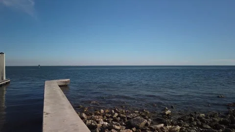 Pan left to right View from Bay Vista Park boat dock over rocks with boat dock r Stock Footage 265716262