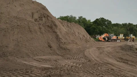 Pan left to right Wide view  dirt pile on left to construction equipment Electri Stock Footage 281992549
