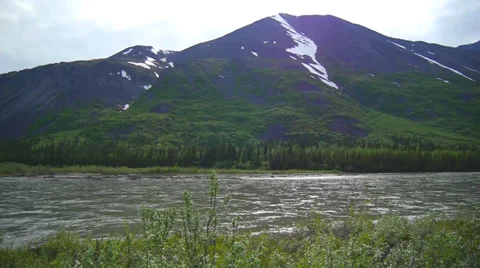 Pan Left  River Flows Through Grassy Mountain Valley Stock Footage 37434004