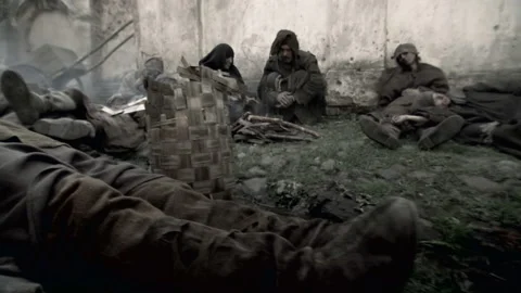 Pan left shot of recreation: sick people lying the streets coughing Stock Footage 202909512