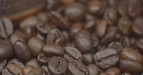 Pan to left shot of roasted coffee beans near coffee turk slow motion Stock Footage 129382834