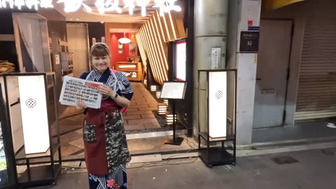 Pan Left Shot of Smiling Japanese Waitress Outside Teppanyaki Restaurant Stock Footage 337745665