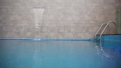 Pan left shot of swimming pool with waterfall Stock Footage 167258557