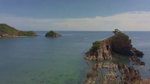 Pan left from a small island islet towards holidays resorts on an island. Vídeo Stock 135140830