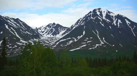 Pan Left Snow Capped Mountain Range with Evergreen Trees Stock Footage 37434676