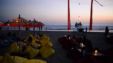 Pan left sunset chill bean bag bar beach Stock Footage 124146640