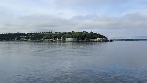 Pan left of the West Seattle area of Alki beach from the Puget Sound in Stock Footage 141653761
