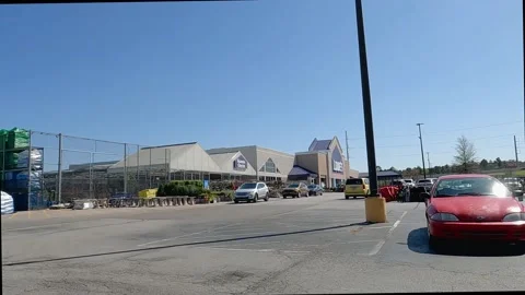 Pan of Lowes retail store pallets of potting spoil parking lot cars and clear Stock Footage 172422592