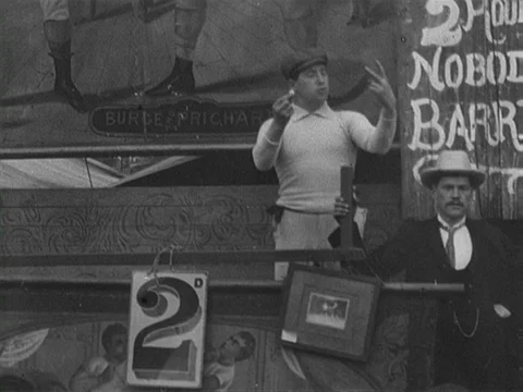 Pan of men trying to attract visitors to their show at Hull fair, UK 1902 Stock Footage 136676390