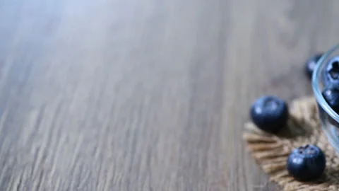 Pan motion from left to right of Blueberry with leaves in glass cup Stock Footage 171123842