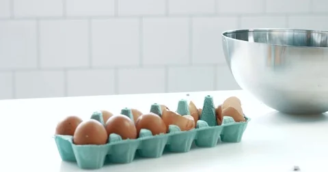 Pan movement of camera showing table with eggs and a bowl ready to make a cake Stock Footage 77910991