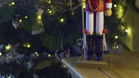 Pan up on Nutcracker toy in front of Christmas tree Stock Footage 82915359