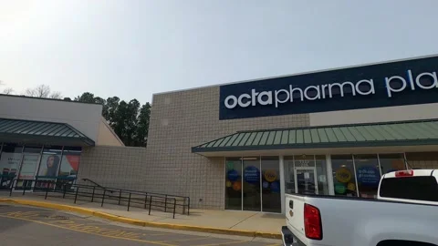 Pan of Octapharma Plasma facility building and a white truck with a person Stock Footage 147898143