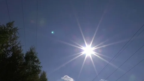 Pan from one power line to another, the sun in between, lens flares Stock Footage 76765222