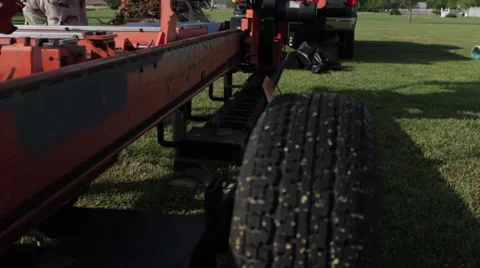 Pan up to operator readying portable sawmill Stock Footage 40472229