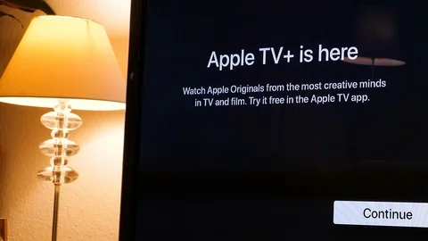 Pan over Apple TV plus is here message on living room Stock Footage 120365034