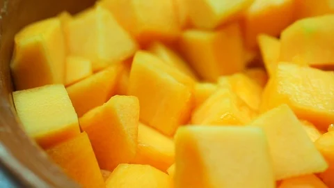 Pan over of bright mango chunks in fruit bowl Stock Footage 120406641