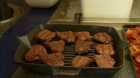 Pan over buffet with cast iron pan of steak and bacon Stock Footage 123774575
