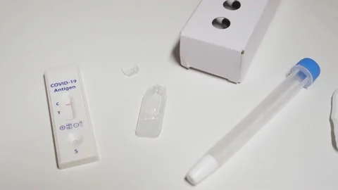 Pan over Covid-19 antigen self testing kit with negative result on device Stock Footage 169407380