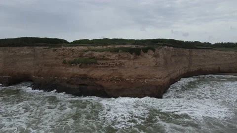 Pan over crashing waves on cliff in a cloudy day in Mar del Plata City, Argen Vídeo Stock 152667997