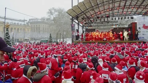 Pan over crowd of happy Santa Clauses waving hands in air shaking dancing Video stock 70633285