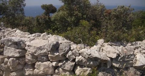 Pan over a dry stone wall with macchia in the background at the island losinj 動画素材 111898284
