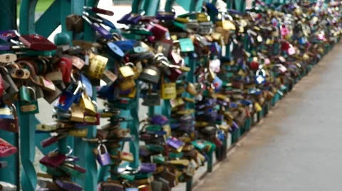 A pan over large number of padlocks on lovers bridge with river in background Stock Footage 67894566