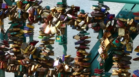 A pan over large number of padlocks on lovers bridge with river in background Stock Footage 67894619