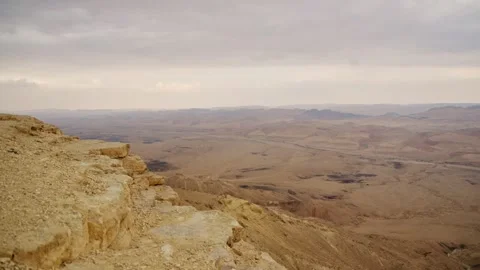 Pan over the open desert terrain of Ramon Crater in Southern Israel at sunset Stock Footage 302743483