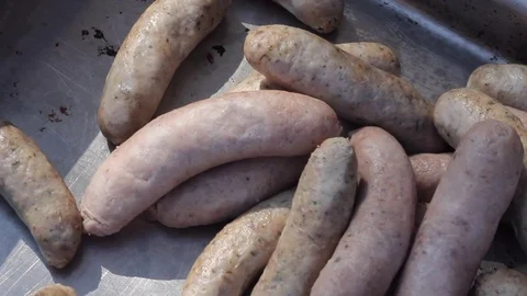 Pan over raw sausages before they are cooked at a BBQ Stock Footage 80436196