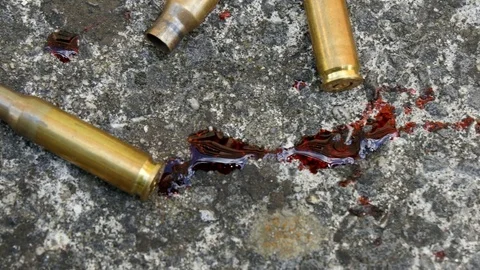 Pan over spent bullets and bloodstains Stock Footage 77784191