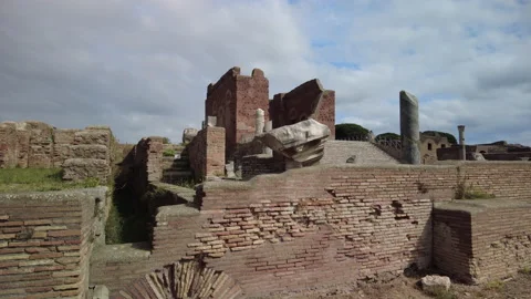 Pan up over a wall towards the Capitolium in ancient Ostia Antica, Rome Stock Footage 160731769