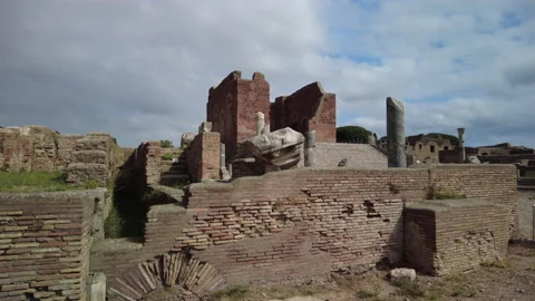 Pan up over a wall towards the Capitolium in ancient Ostia Antica, Rome Stock Footage 160737561