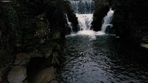 Pan up over waterfall and trees Stock Footage 73559786