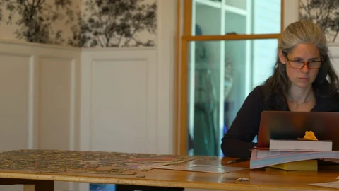 Pan from parent to child doing schoolwork at home Stock Footage 129963548