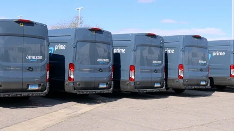 Pan of parked Amazon Prime delivery vans Stock Footage 126567114