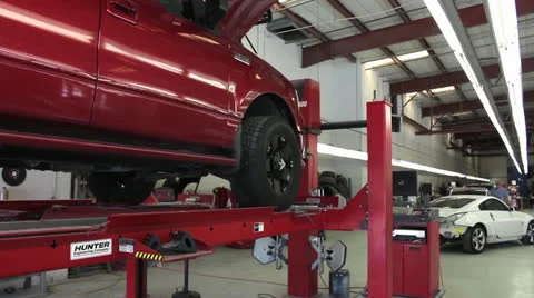 Pan past truck on alignment rack at auto body shop Stock Footage 26148875