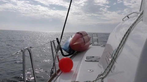Pan from portside of catamaran by helm up to the main sail moving in the wind Stock Footage 67956420