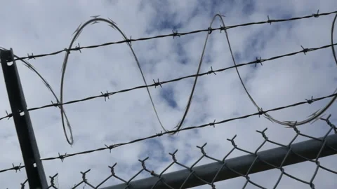 A pan of razor ribbon on a prison or security fence Stock Footage 229215342