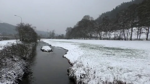 Pan: recently renaturated stream Lauter in winter, snowy fields and trees, water Stock Footage 99873877