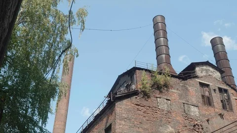 Pan of red brick wall of abandoned metallurgic plant with three chimneys. Stock Footage 121629392