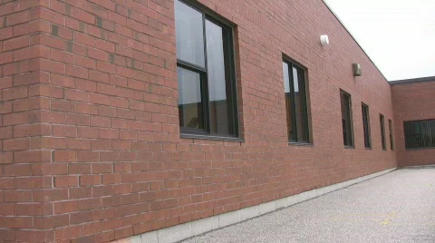 Pan of red bricked school and empty school yard Stock Footage 518009