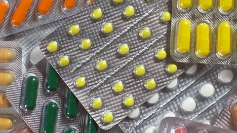 Pan red, pink and white tablet camera above. Slow panorama drug macro. Stock-Footage 73034133